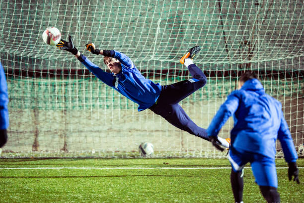 gardien de but attraper le ballon dans les airs - throwing football men ball photos et images de collection