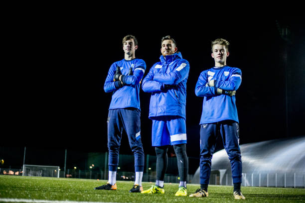 Goalkeepers and their Coach on Soccer Field.