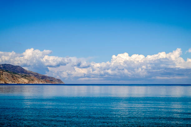 Akrotiri peninsula and clouds reflected on calm sea, Crete, Greece