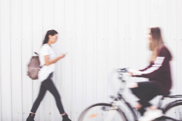 Two young woman walking and cycling outside
