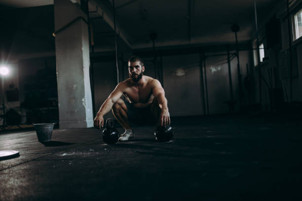 istock Man workout with kettlebells in the gym 929800736