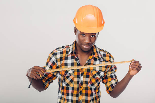 istock African-American builder uses measuring tape 929803388