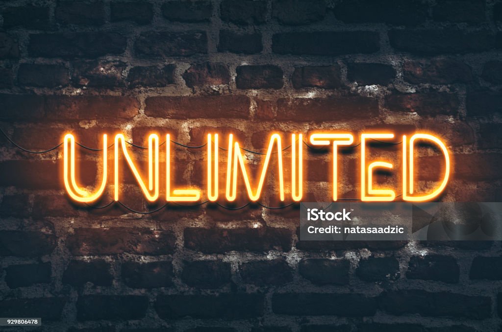 Unlimited Unlimited neon sign on dark brick wall background Infinity Stock Photo
