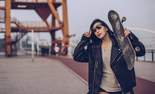istock Woman holding skateboard on the shoulder 929816190