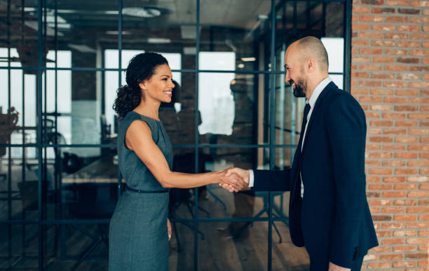 hombres de negocios estrechándose las manos  - men women handshake business fotografías e imágenes de stock