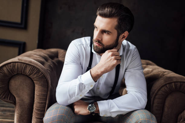 istock handsome pensive man sitting in armchair 929818254