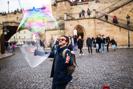 Tourist in Prague playing with soap balloons