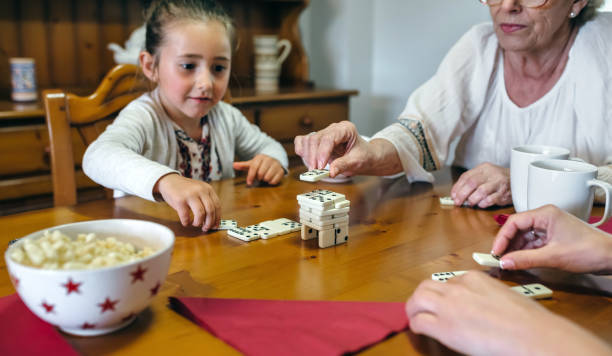 istock Three female generations playing with dominoes 929826684