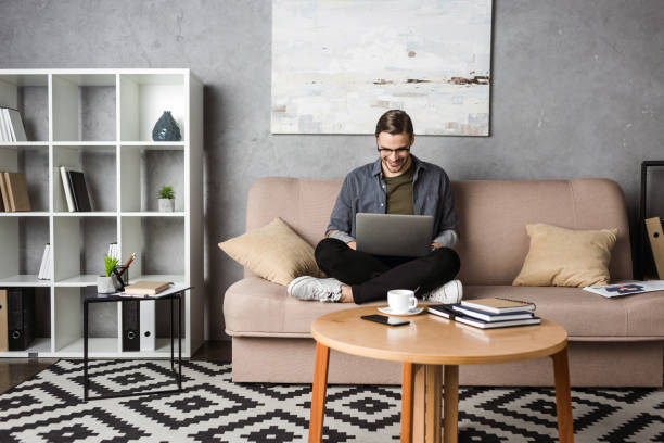 istock young happy freelancer working with laptop while sitting on couch 929844286