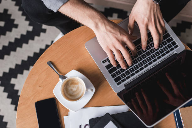 istock cropped shot fo man using laptop on coffee table 929848844