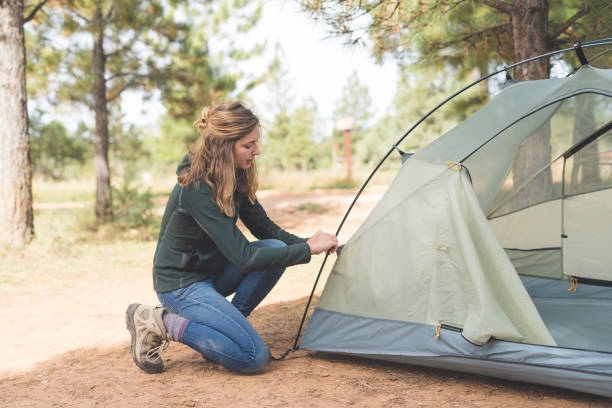 istock Young woman sets up a tent 929861944