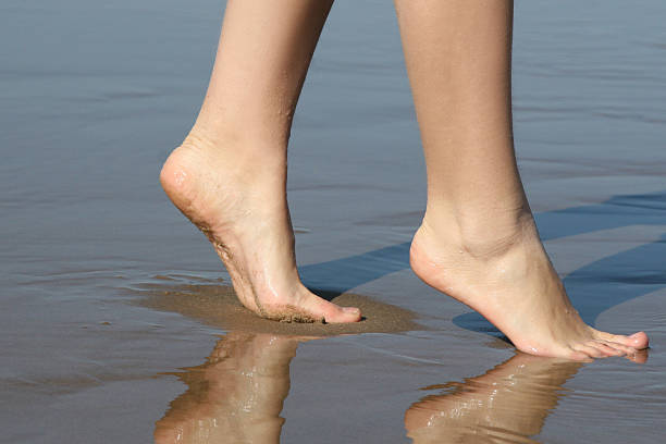 istock Beautiful female feet on sea sand 92986407