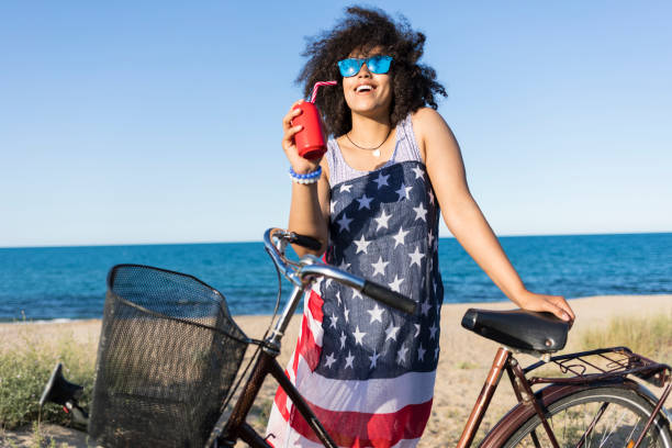 istock Young african woman drinking cocktail on beach 929868752
