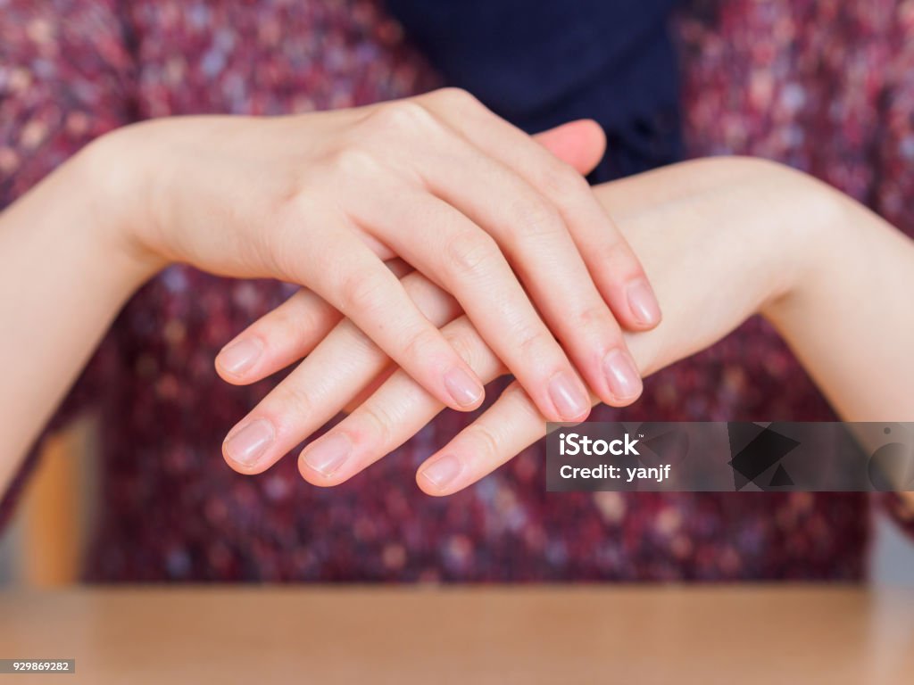 The girl crossed the beautiful hands, tenderness and sensuality, skin care concept. Fingernail Stock Photo