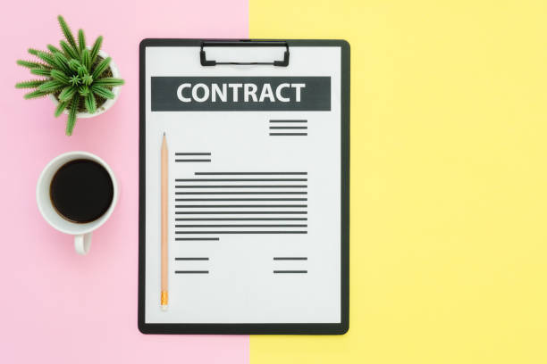 istock Flat lay design of office desk working space  - Top view of a contract document and coffee cup decorated with small cactus on pink yellow pastel color with copy space. Pastel working space background. 929870286