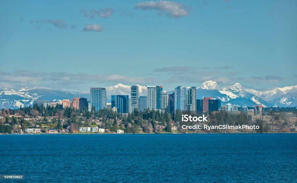 Bellevue, Washington and Cascade Mountains over Lake Washington The Snow Capped Cascade Mountain Range stand Tall Behind the City of Bellevue, Washington and Lake Washington on a Sunny and Blue Afternoon Bellevue - Washington State Stock Photo