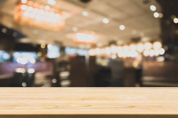 istock wood table with abstract blurred cafe restaurant with bokeh lights defocused background 929877362