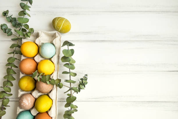 istock Easter eggs colored with natural paints on white wooden table. Flat lay 929877826