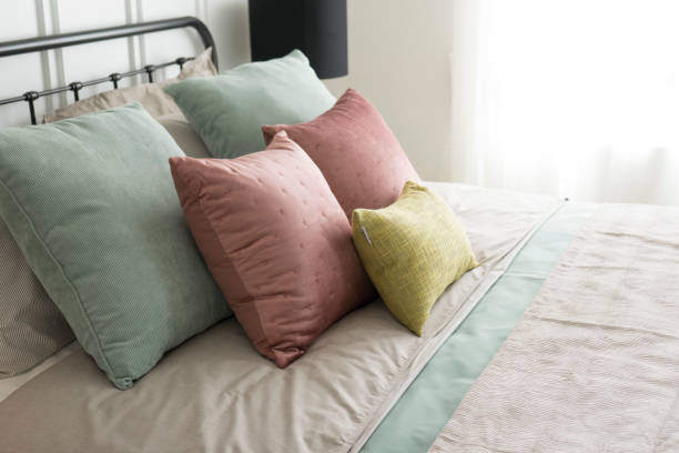 istock cozy bedroom with pastel pink and green pillows. 929878360