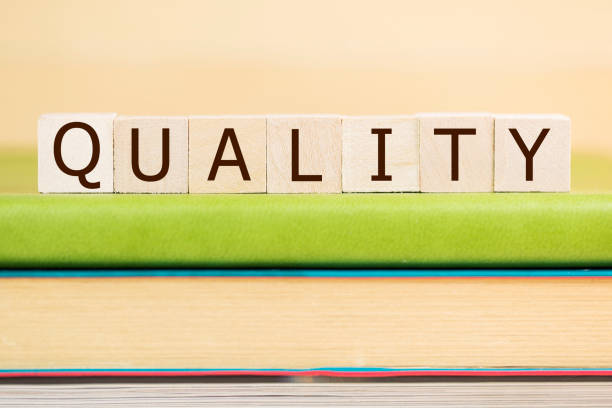istock Quality word built with letter cubes on green book 929883400