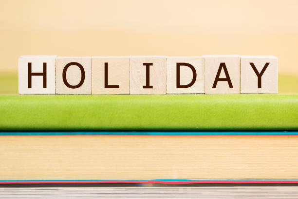 istock Holiday word built with letter cubes on green book 929883404