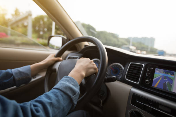 istock Hands on wheel driving car in city 929887364