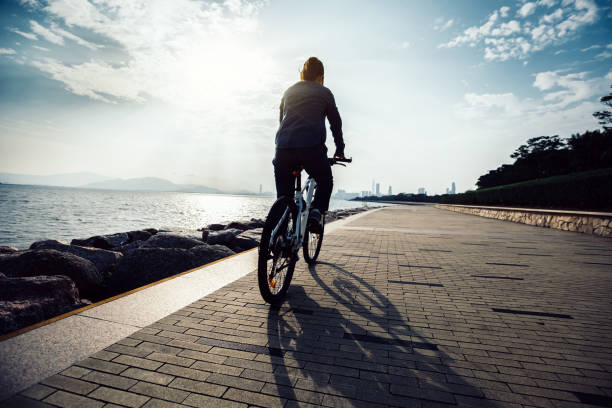 istock cyclist riding bike in the sunrise coast path 929887876