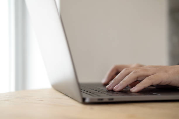 istock Closeup image of hands working and typing on laptop keyboard on wooden table 929888604