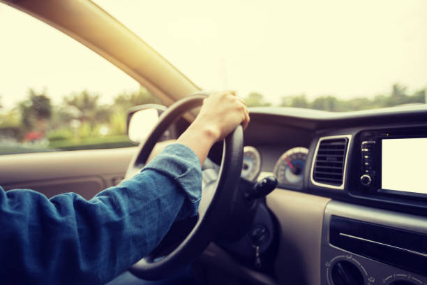 istock Hands on wheel driving car in city 929890718