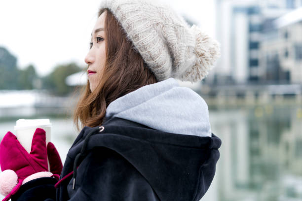 istock young woman with coffee standing at bridge 929890836