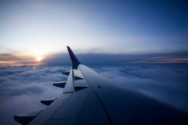 istock Morning sunrise with Wing of an airplane. 929890982
