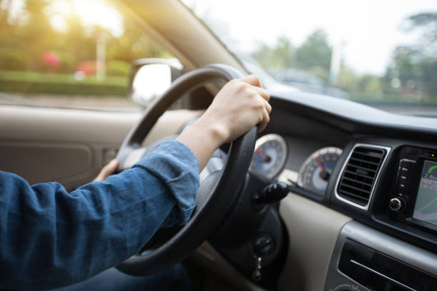 istock Hands on wheel driving car in city 929894468