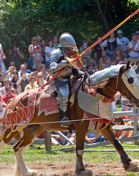 Knight em armadura em um cavalo de carregamento, Combate com Lanças - foto de acervo