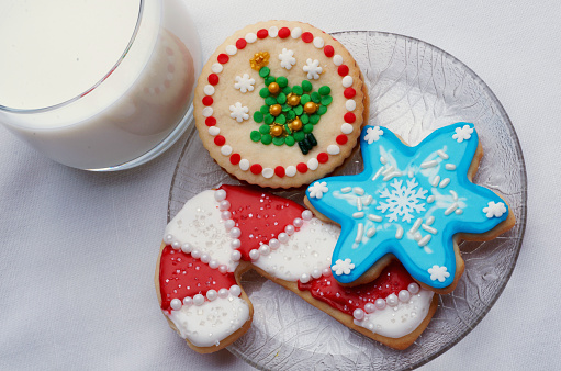 Various shaped Christmas cut-out cookies that are artistically decorated with colored icing and decorations.