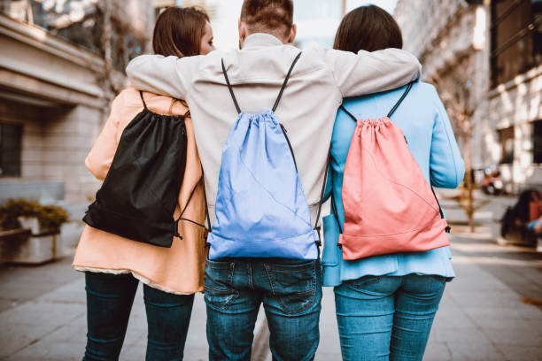 istock Group of Embraced Students with Backpacks Walking After School 929900690
