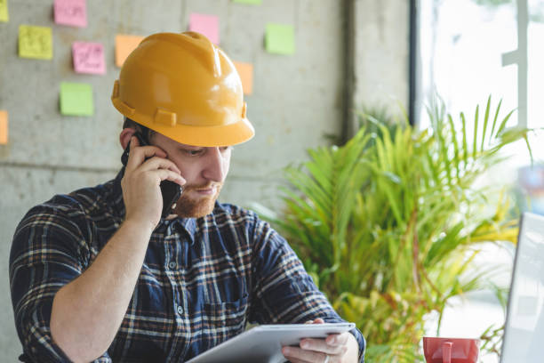 istock Engineer talking with phone and looking at tablet in office. 929910986