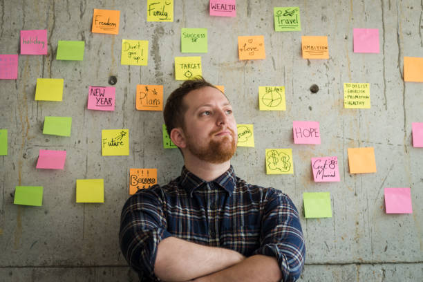 istock Happy man crossed arm with sticky notes chart on cement wall.  Entrepreneur concept. 929911024