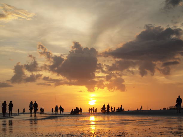 istock SUNSET SILHOUETTE OF PEOPLE WALKING BEACH 929911426