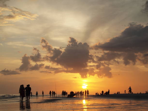 istock SUNSET SILHOUETTE OF PEOPLE WALKING BEACH 929911428