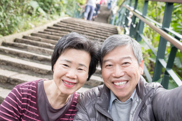 old couple selfie happily in the park and climb mountain