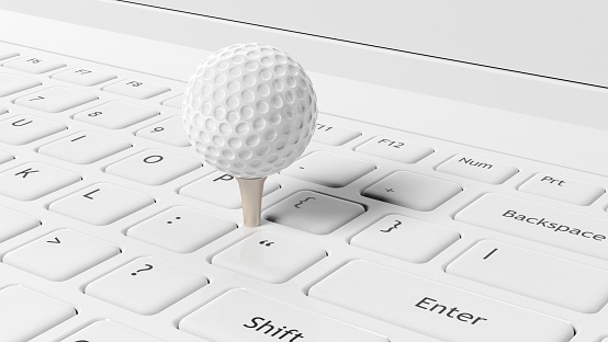 Golf ball on white laptop keyboard