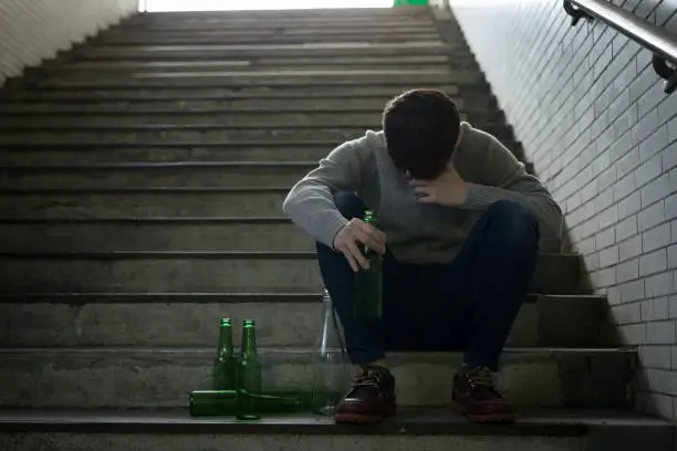 depressed man feel upset with alcoholism problem and sit in underground road