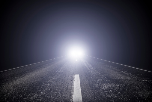 Nighttime city lights guiding the way: Driving on wet road among street lights. Elevated road under the path in Tampa, Florida