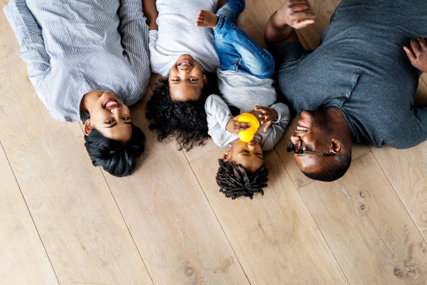 istock Black family lying on wooden floor design space 929930110