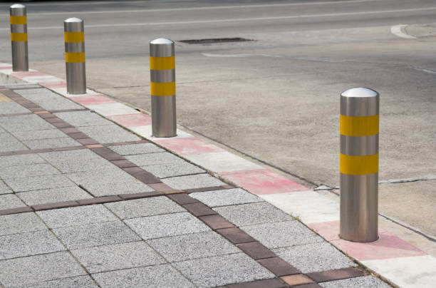 istock Stainless Steel bollards on grey stone pavement 929937102