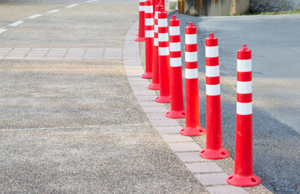 Orange plastic bollards with traffic reflective on footpath