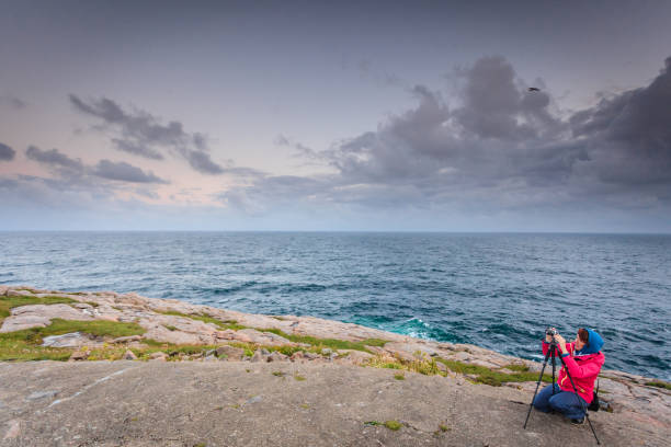 istock Tourist with camera on seashore, Norway 929941156