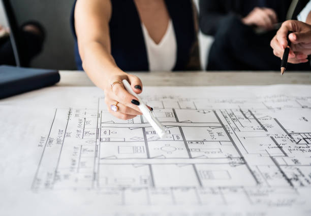 istock Woman pointing at building plan 929941802