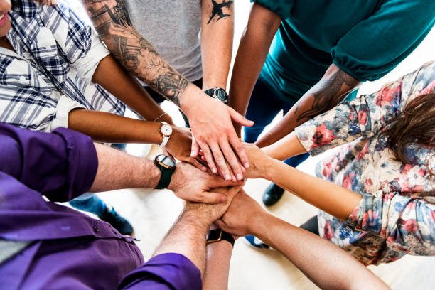 istock Group of diverse people joined hands together teamwork 929945748
