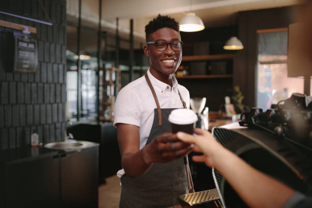 barista obsługujący klientów w kawiarni - barista zdjęcia i obrazy z banku zdjęć